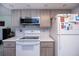 This kitchen boasts gray cabinets, white appliances, and ample counter space for meal preparation at 2113 Barksdale St, Port Charlotte, FL 33948