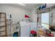A well-lit laundry room equipped with a washer, dryer, utility sink, and convenient shelving at 2113 Barksdale St, Port Charlotte, FL 33948