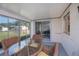Enclosed patio with a glass table and seating, offering views of the backyard at 2113 Barksdale St, Port Charlotte, FL 33948