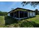 The rear of the home shows a fully screened in porch creating an extension of living area at 2113 Barksdale St, Port Charlotte, FL 33948