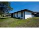 View of the rear exterior featuring a well-maintained lawn and partial privacy at 2113 Barksdale St, Port Charlotte, FL 33948