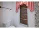 Toilet area with a window, complete with charming pink valances and a towel rack at 2113 Barksdale St, Port Charlotte, FL 33948