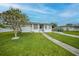 Well-kept single-story home with green lawn, walkway, and tree in the front yard at 2321 Dallas St, Port Charlotte, FL 33952