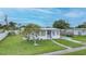 Cozy one-story house with a green lawn and a mature tree in the front yard at 2321 Dallas St, Port Charlotte, FL 33952