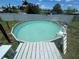 Above-ground pool with a ladder surrounded by a wooden deck in the backyard, perfect for summer fun at 2321 Dallas St, Port Charlotte, FL 33952