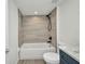A bathroom featuring a tub and shower combination with grey tile and a blue vanity with marble countertop at 23465 Harborview Rd # 1002, Punta Gorda, FL 33980