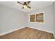 Bedroom with hardwood floors, neutral paint and window with wood-look blinds and a ceiling fan at 23465 Harborview Rd # 1002, Punta Gorda, FL 33980