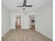 Bedroom with wood floors, ceiling fan, and doorway to the updated kitchen at 23465 Harborview Rd # 1002, Punta Gorda, FL 33980