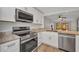 Bright kitchen with stainless appliances, granite counters, and open view to living area at 23465 Harborview Rd # 1002, Punta Gorda, FL 33980