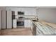 Modern kitchen with stainless steel appliances, granite countertops, white cabinets, and tile flooring at 23465 Harborview Rd # 1002, Punta Gorda, FL 33980