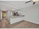 Living room with hardwood floors open to the kitchen with bar seating and neutral paint at 23465 Harborview Rd # 1002, Punta Gorda, FL 33980