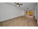 Living room with hardwood floors, neutral paint, sliding glass doors to the lanai and a ceiling fan at 23465 Harborview Rd # 1002, Punta Gorda, FL 33980