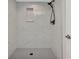 Modern shower with white marble style tile and a black shower head at 23465 Harborview Rd # 1002, Punta Gorda, FL 33980