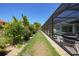Grassy backyard with lush landscaping and screened-in patio and pool is great for entertaining and relaxing at 25273 Paraguay St, Punta Gorda, FL 33983