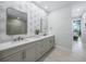 Elegant bathroom featuring a dual sink vanity, decorative wallpaper, and wood look tile flooring at 25273 Paraguay St, Punta Gorda, FL 33983