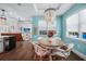 Charming dining area with stylish chandelier and aqua colored walls leading into the living room at 25273 Paraguay St, Punta Gorda, FL 33983