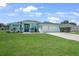 Well-kept exterior with a two-car garage, lush lawn, and freshly manicured landscaping at 25273 Paraguay St, Punta Gorda, FL 33983
