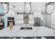 Modern kitchen featuring white cabinets, stainless steel appliances, and a marble countertop island at 25273 Paraguay St, Punta Gorda, FL 33983