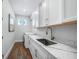 Well-lit laundry room features modern appliances, white cabinetry and countertop space at 25273 Paraguay St, Punta Gorda, FL 33983