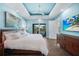 Spacious main bedroom showcasing a tray ceiling, serene wall art, and a view of the outdoor patio at 25273 Paraguay St, Punta Gorda, FL 33983