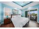 Beautifully designed main bedroom with tray ceiling, a sliding glass door, and neutral decor at 25273 Paraguay St, Punta Gorda, FL 33983