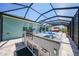The screened-in patio includes a grill and sink area with views of the pool and outdoor dining space at 25273 Paraguay St, Punta Gorda, FL 33983
