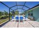 Screened patio with tile flooring, dining set, bench, and view of the yard offers relaxation and entertainment at 25273 Paraguay St, Punta Gorda, FL 33983