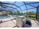 This screened patio features an outdoor kitchen, pool, and dining area for the perfect entertainment space at 25273 Paraguay St, Punta Gorda, FL 33983
