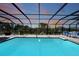 Sparkling screened-in pool with ample seating and lush landscaping, perfect for relaxation and entertaining at 25273 Paraguay St, Punta Gorda, FL 33983