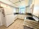 Well-lit kitchen with white cabinets, granite countertops, and tiled floor at 261 Caddy Rd, Rotonda West, FL 33947