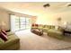 Cozy living room with comfortable green couches, bright natural light, and carpeted floor at 261 Caddy Rd, Rotonda West, FL 33947