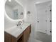 Bright bathroom with a quartz countertop, built-in storage and LED mirror at 27385 Voyageur Dr, Punta Gorda, FL 33983