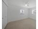Clean, simple bedroom with tiled floors, a ceiling fan, and two windows at 27385 Voyageur Dr, Punta Gorda, FL 33983