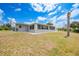 Exterior view of single story home with an enclosed patio and expansive backyard and grassy area at 27385 Voyageur Dr, Punta Gorda, FL 33983