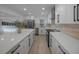 Spacious kitchen showcasing sleek stainless steel appliances, white cabinets, and center island at 27385 Voyageur Dr, Punta Gorda, FL 33983