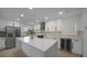 Modern kitchen with white cabinets, stainless steel appliances, large island, and a beverage cooler at 27385 Voyageur Dr, Punta Gorda, FL 33983