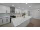 Modern kitchen with white cabinets, stainless appliances, and large center island with countertop seating at 27385 Voyageur Dr, Punta Gorda, FL 33983