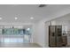 Open kitchen and living room with stainless steel appliances, white cabinets, and adjacent sunroom with many windows at 27385 Voyageur Dr, Punta Gorda, FL 33983