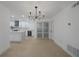 Open-concept design boasts modern kitchen with white cabinetry, island, and stainless steel appliances at 27385 Voyageur Dr, Punta Gorda, FL 33983