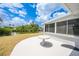 Outdoor patio with a pristine white table, overlooking a canal with lush greenery and a clear blue sky at 27385 Voyageur Dr, Punta Gorda, FL 33983