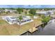 Rear exterior showcasing new solar panels, screened patio, and wooden dock on the canal at 27385 Voyageur Dr, Punta Gorda, FL 33983
