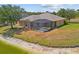Drone view showing lakefront home with screened pool enclosure and mature landscaping at 2871 Suncoast Lakes Blvd, Punta Gorda, FL 33980