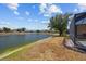 A tranquil backyard view of the lake, lush greenery, and landscaping details offering a serene outdoor experience at 2871 Suncoast Lakes Blvd, Punta Gorda, FL 33980