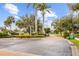Inviting community entrance with manicured landscaping, palm trees, and a brick-paved street at 2871 Suncoast Lakes Blvd, Punta Gorda, FL 33980