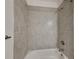 New bathroom with tub, gray tile surround, and brushed nickel fixtures at 298 Overbrook St, Port Charlotte, FL 33954
