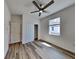 Bright bedroom with wood-look floors, ceiling fan, window, and closet at 298 Overbrook St, Port Charlotte, FL 33954