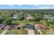 This aerial view shows a neighborhood with mature trees, green lawns, and a home with solar panels at 3544 Monfero Ave, North Port, FL 34286