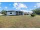 View of backyard, featuring a covered patio, privacy fence, and well-manicured lawn at 3544 Monfero Ave, North Port, FL 34286