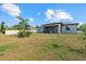 View of backyard, featuring a covered patio, privacy fence, and well-manicured lawn at 3544 Monfero Ave, North Port, FL 34286