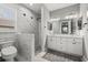 Modern bathroom with marble tile shower, double vanity sinks, and stylish lighting fixtures at 3544 Monfero Ave, North Port, FL 34286